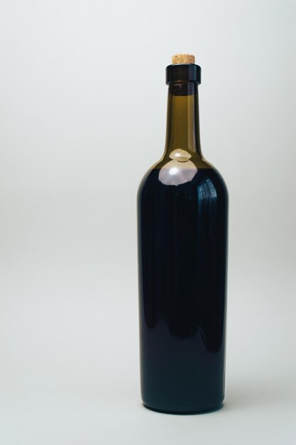 Bottle of red wine on a old oak wooden table and gray background