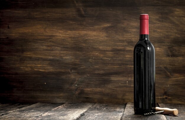 bottle of red wine. On a wooden background.