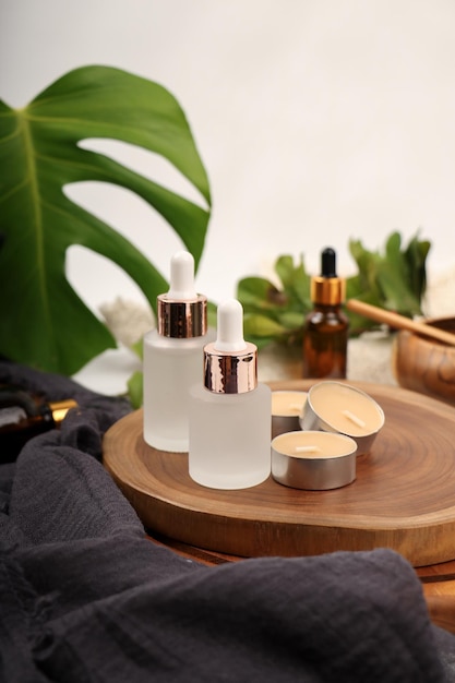 a bottle of serum sits on a tray with a candle of perfume