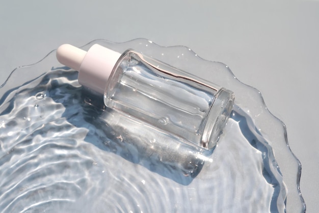 A bottle of serum in water on a blue background