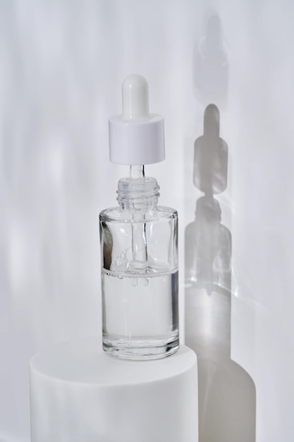 A bottle of serum in water on a white background