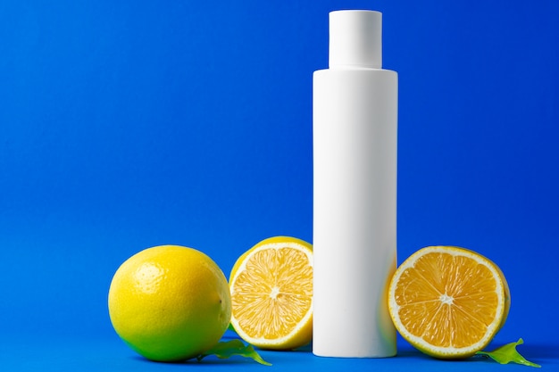 Bottle of skincare cosmetics with sliced lemons