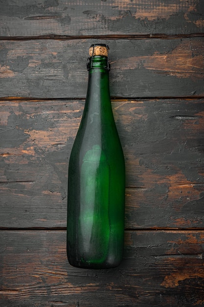 スパークリングワインセットのボトル、古い暗い木製のテーブルの背景、上面図フラットレイ
