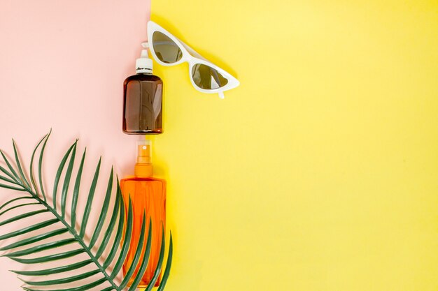 Bottle sunblock on bright square yellow and pink