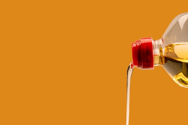 A bottle of sunflower oil isoalted on an orange background