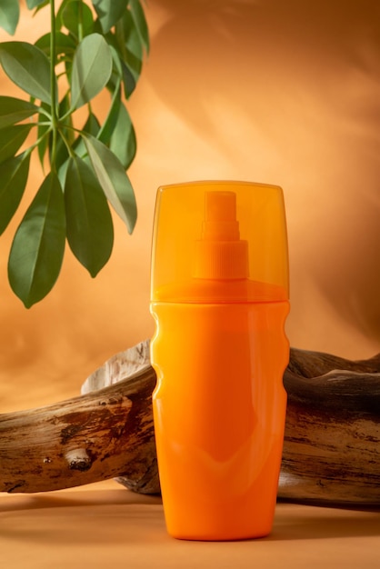 Bottle of sunscreen on orange background