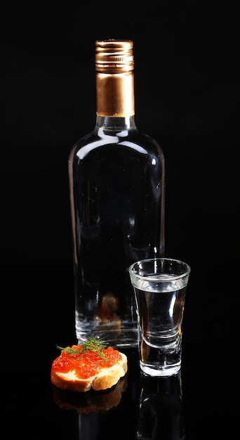 Bottle of vodka red caviar isolated on black