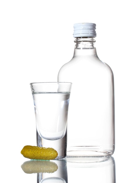 Foto bottiglia di vodka e bicchiere di vino con cetriolo isolato su bianco