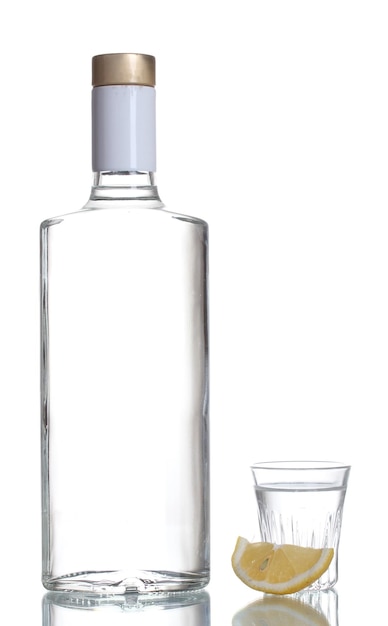 Bottle of vodka and wineglass with lemon isolated on white