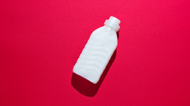 Bottle of washing gel on red surface 