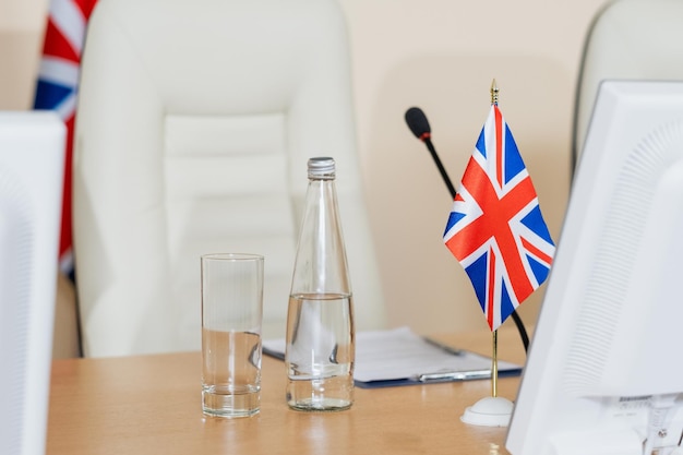 Бутылка стакана воды и британский флаг на рабочем месте делегата