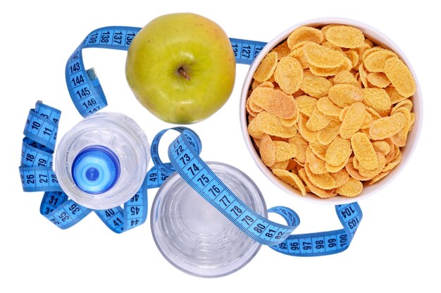 Bottle of water, green apple, glass of water, bowl of cornflakes