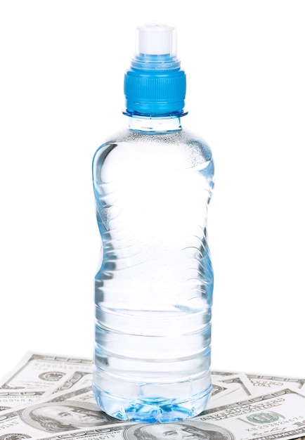 Foto bottiglia d'acqua su un mucchio di dollari isolata su uno sfondo bianco