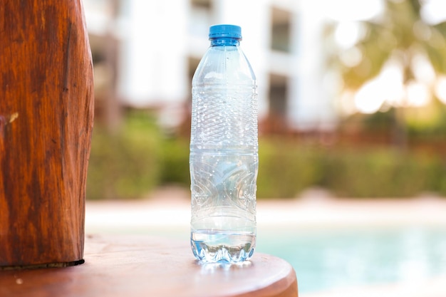 A bottle of water next to a pool