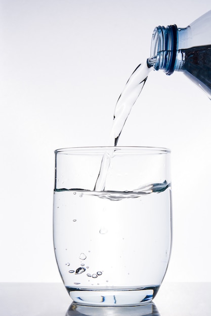 Bottle of water pouring water into a glass