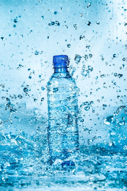Foto bottiglia d'acqua spruzzata su sfondo blu