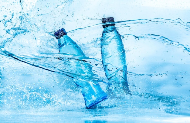 青い背景に水のしぶきのボトル