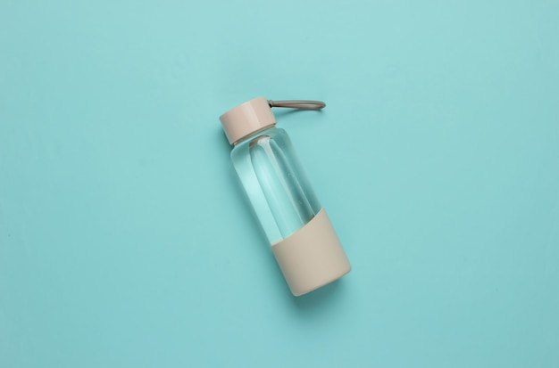 Photo bottle of water for sports and outdoor activities on blue background. top view