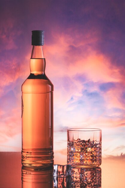 Foto bottiglia di whisky in un cielo nuvoloso al tramonto