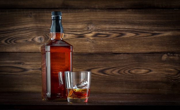 Bottle of whiskey on a wooden background