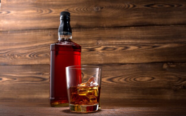 Bottle of whiskey on a wooden background