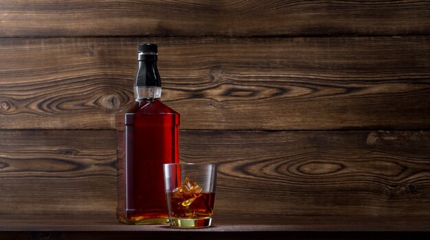 Bottle of whiskey on a wooden background