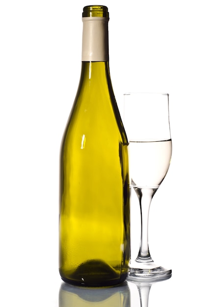 Bottle of white wine and glass over light grey