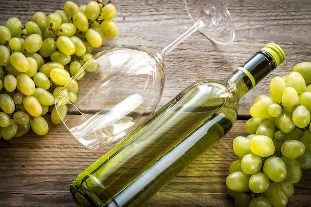 Bottle of white wine with bunch of grape