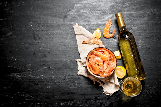 Bottle of white wine with shrimp and lemon.