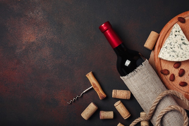 Foto bottiglia di vino, mandorle, cavatappi e tappi di sughero, vista dall'alto