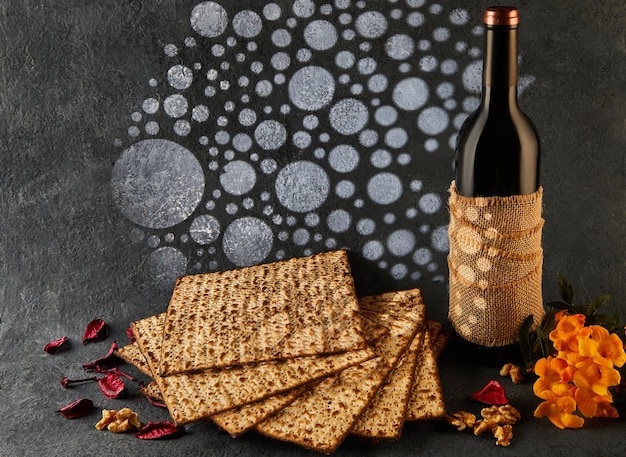 A bottle of wine by matzah flowers Natural foods and cooking ingredients