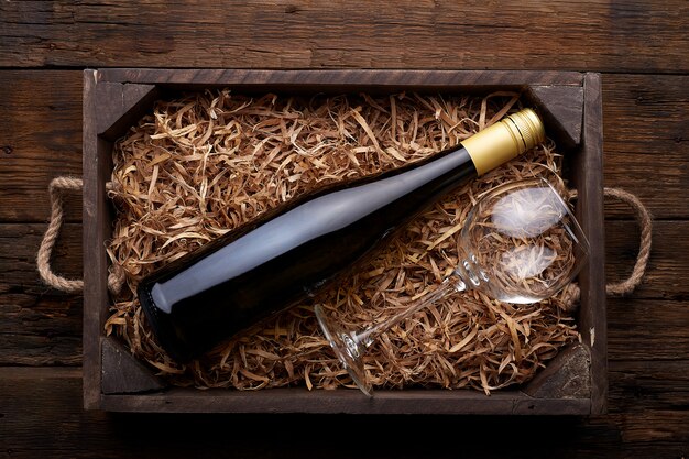 Bottle of wine in case on rustic wood