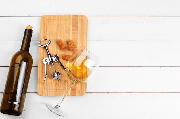 Bottle of wine and cork and corkscrew on wooden table