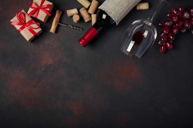 Bottle of wine, gift box, red grapes, corkscrew and corks, 