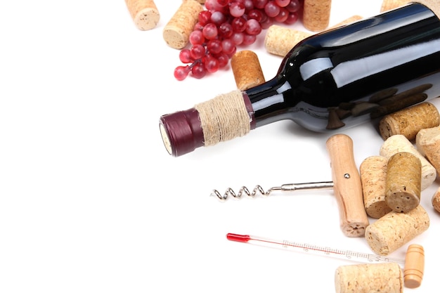 Bottle of wine grapes and corks isolated on white
