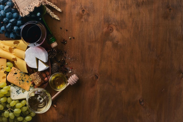 木製のテーブルにワインのボトルとチーズの蜂蜜ナッツとスパイスの大規模な品揃え上面図テキストのための自由なスペース