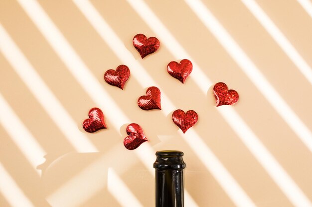 Bottle of wine and red hearts over morning shadow overlay Valentines day beginning concept