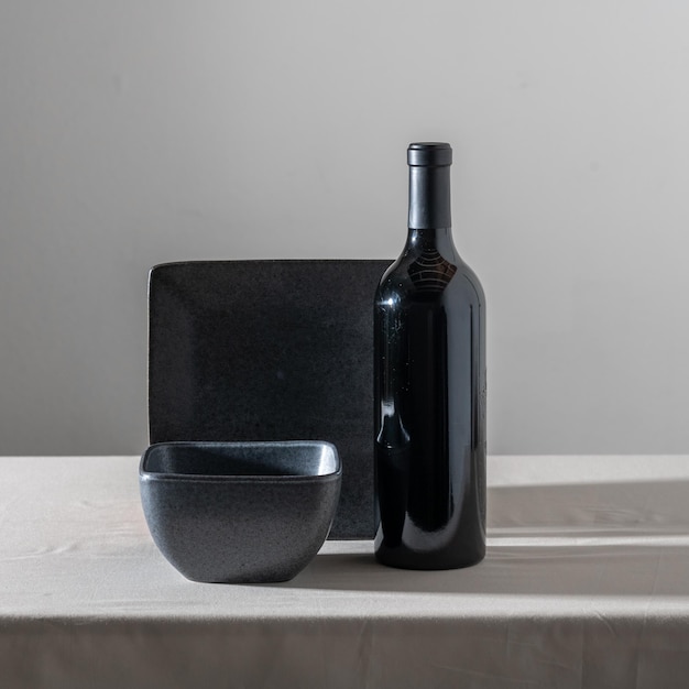 Photo a bottle of wine, , a square black plate