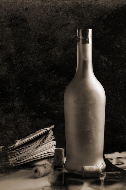 Foto bottiglia di vino su un tavolo con cose antiche, su sfondo nero