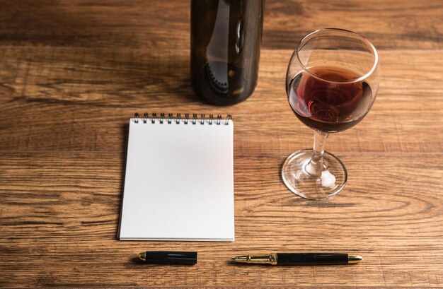 Photo bottle for wine with a glass and a notepad