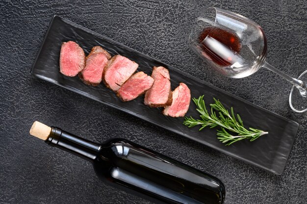 Bottle of wine with sliced filet mignon