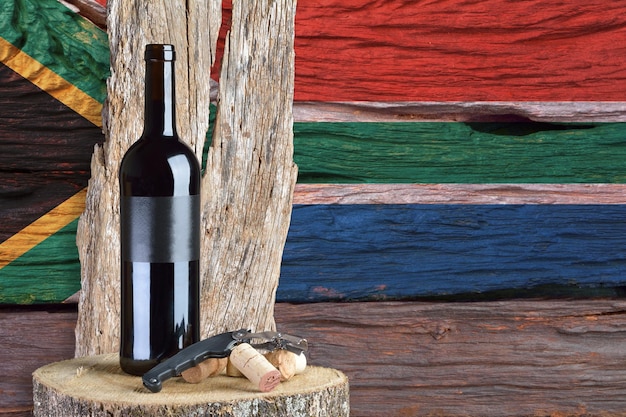 背景に南アフリカの旗とワインのボトル