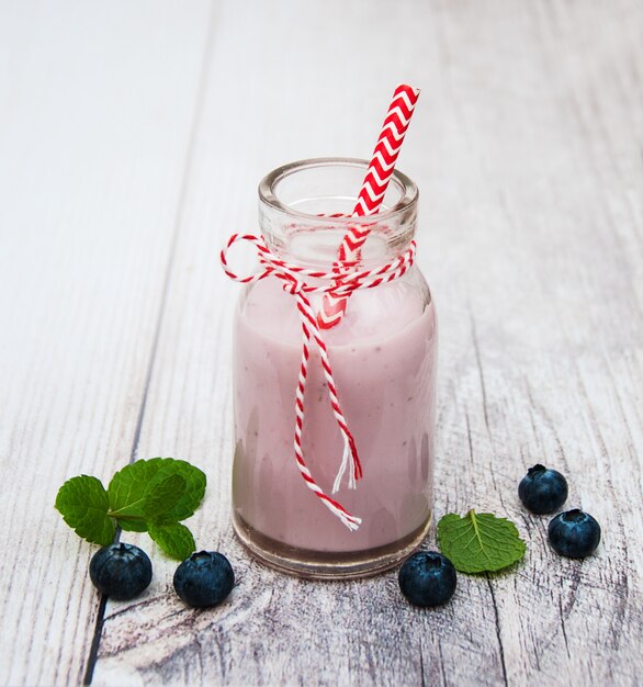 Bottle with blueberry yogurt on a table