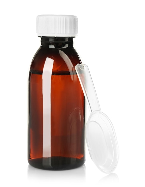 bottle with cough medicine syrup and measuring spoon isolated on white