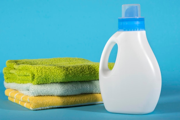 Photo bottle with detergent and towels on a blue background