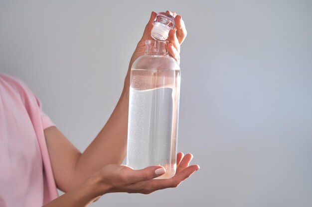 Photo bottle with drinking water in female hands