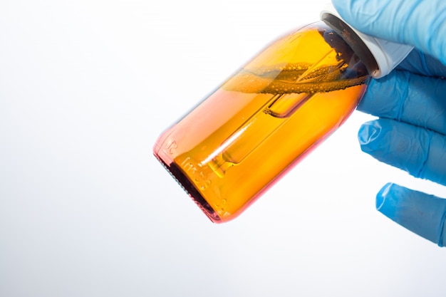 Bottle with dropper in the hands of the doctor in the laboratory. 