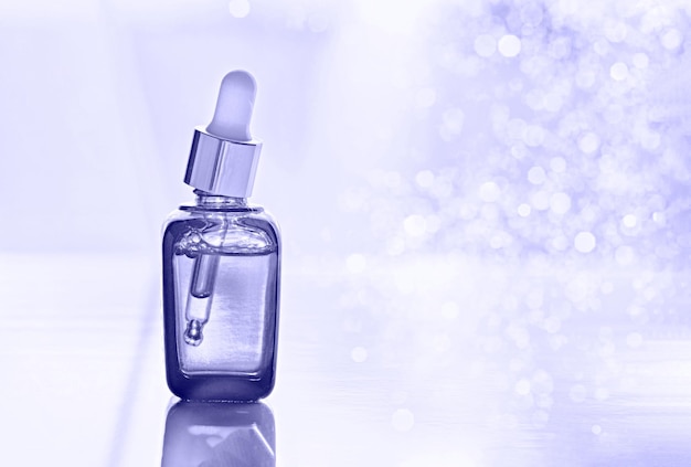 Bottle with fluid collagen of hyaluronic acid. Very Peri color trend 2022. Copy space. Close-up.