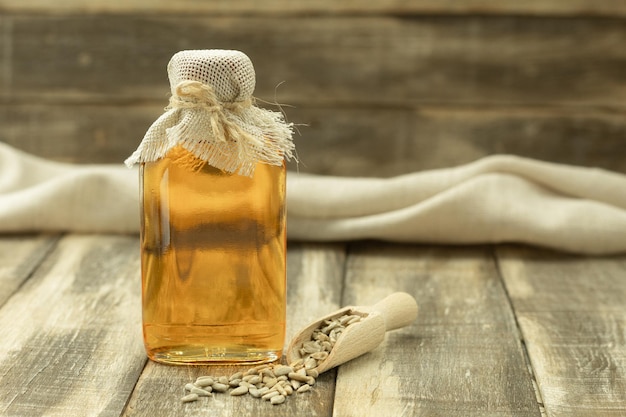 Bottle with fragrant sunflower oil and background with space for text closeup sunflower seeds and sunflower oil in a small decanter