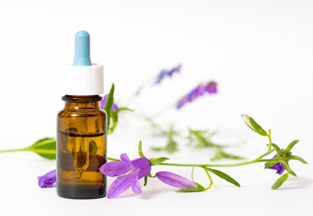 Bottle with herbal oil on white background